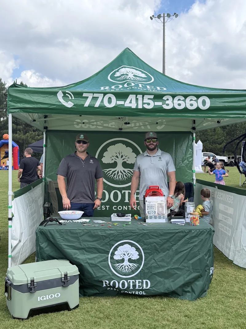 Rooted Pest Control team at a community event tent in West Georgia